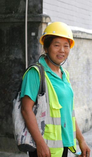 Une femme portant des v&ecirc;tements de travail haute visibilit&eacute; sourit &agrave; la cam&eacute;ra